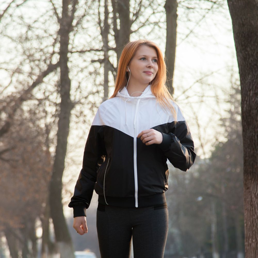 Woman wearing a black and white jacket in a forest setting