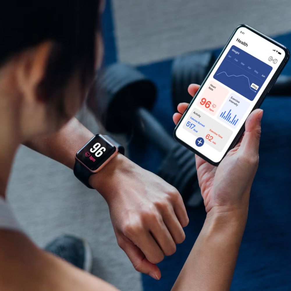 Person using a smartphone app and smartwatch to monitor health metrics.